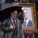 Colin Farrell holds an umbrella in costume as The Penguin on the set of The Batman.